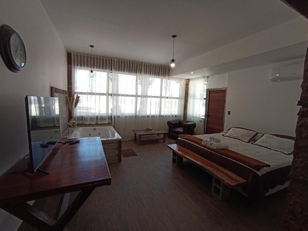 - un salon avec un lit et une baignoire dans l'établissement Uspallata Suites, à Uspallata