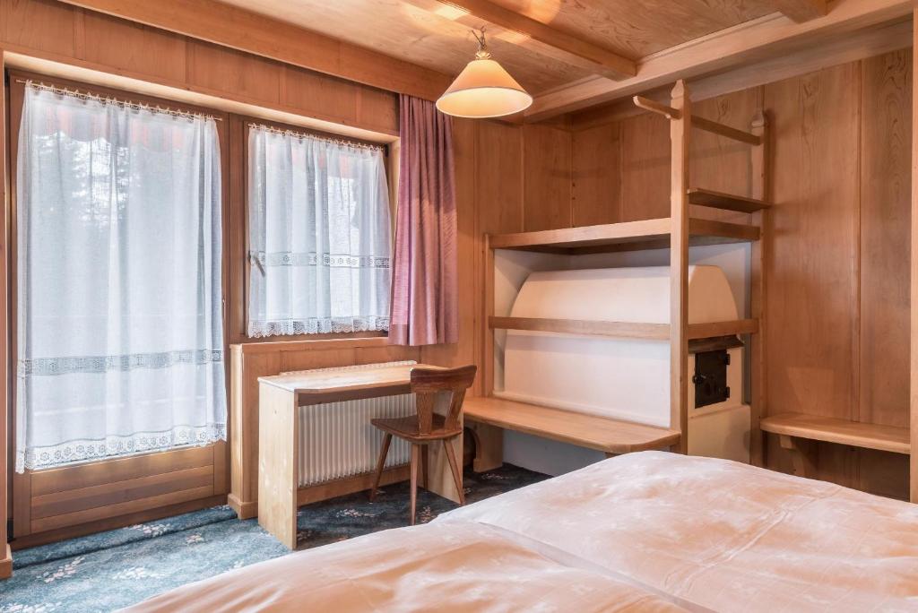 a bedroom with a bunk bed and a desk at Ferienparadies Sabina Spitzbühl in Alpe di Siusi