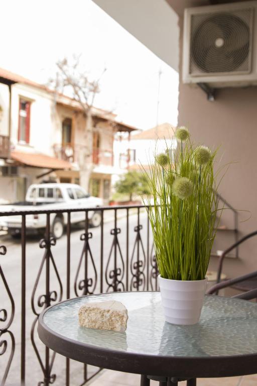 stół z kamieniem i rośliną na balkonie w obiekcie iria's apartments w Limenárii
