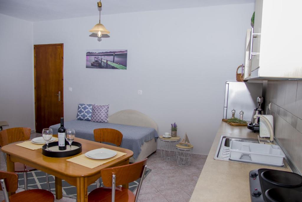 mały pokój ze stołem i łóżkiem oraz kuchnią w obiekcie iria's apartments w Limenárii