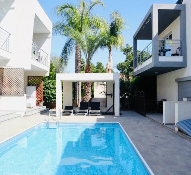a house with a swimming pool in front of a house at Amazing 2-bedroom apartment with pool!! in Limassol