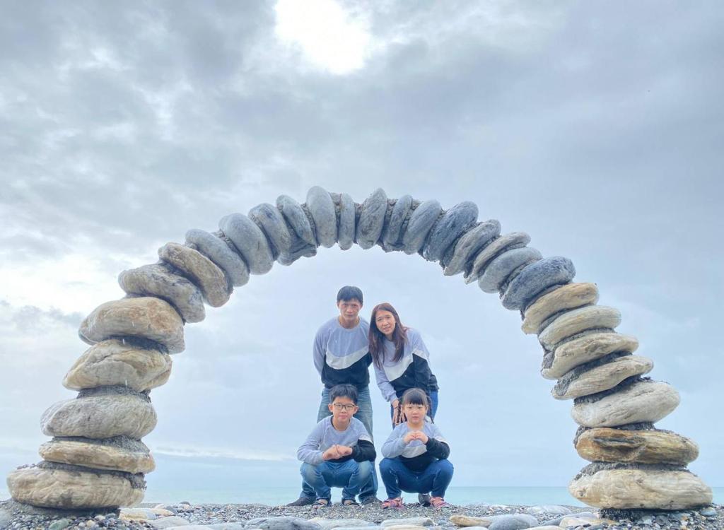 a family posing under an arch on the beach at Hualien Seaside B&amp;B in Hualien City