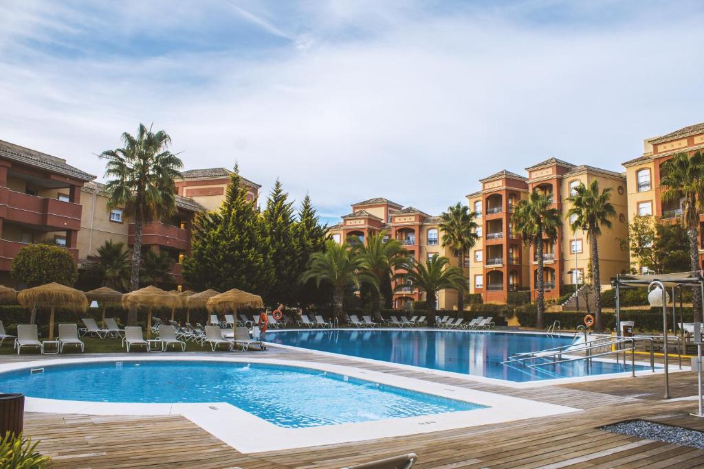 a swimming pool in front of a building at The Residences Islantilla Apartments in Islantilla