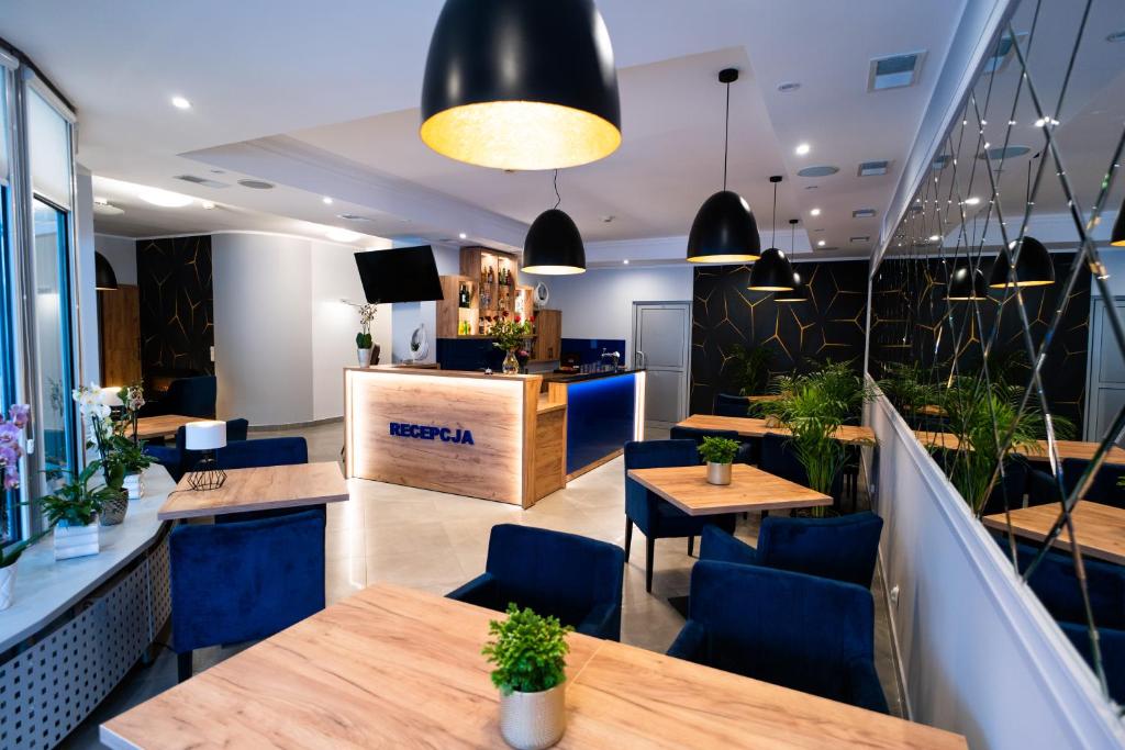 un restaurante con mesas de madera y sillas azules en Centrum Promocji Zdrowia Sanvit en Sanok