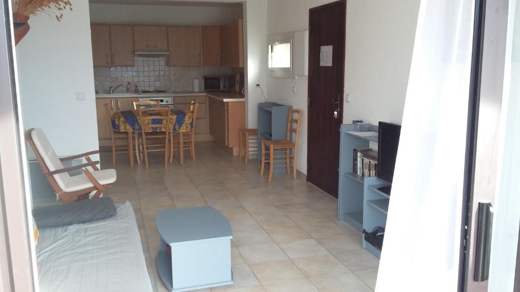 une cuisine et un salon avec une table et des chaises dans l'établissement Les EMERAUDES, à La Croix-Valmer