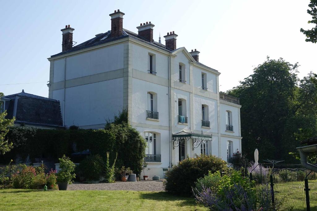 una gran casa blanca con techo en Manoir Le Parc near Paris & Disneyland, en Villevaudé