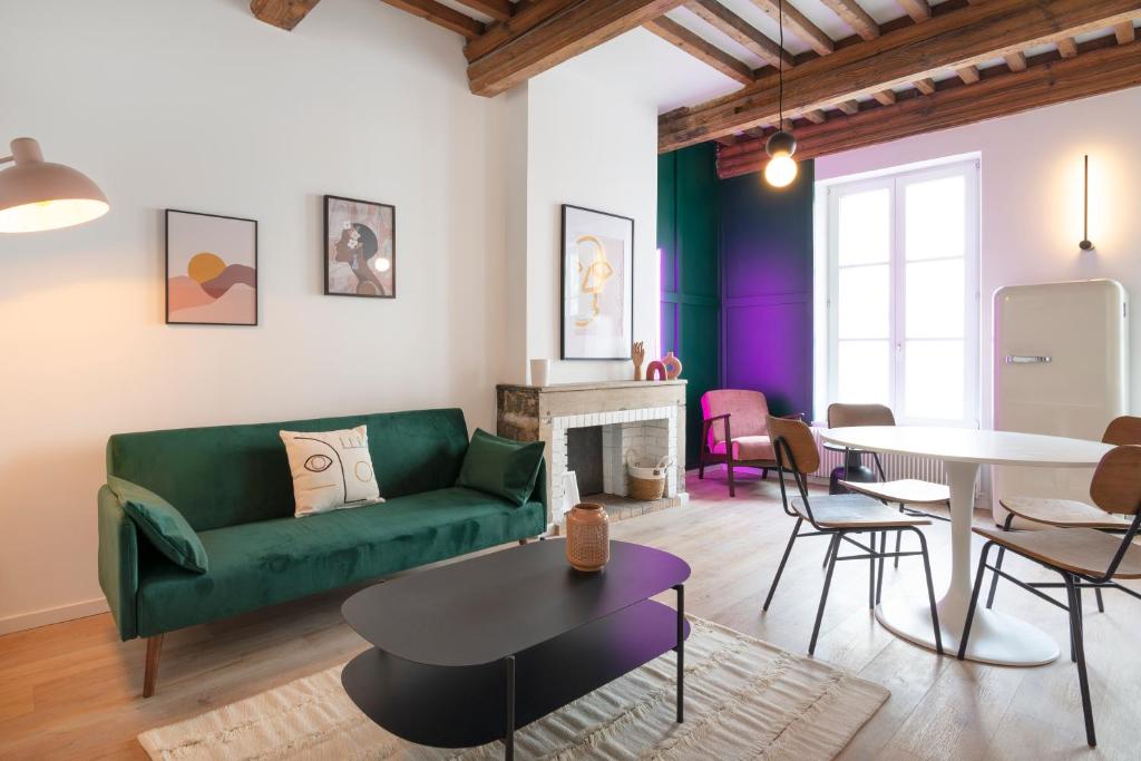 uma sala de estar com um sofá verde e uma mesa em L'irresistible de Guise em Nancy