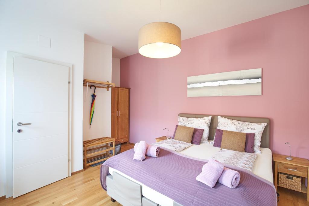 a bedroom with pink walls and a purple bed at Gästezimmer Victoria in Linsberg