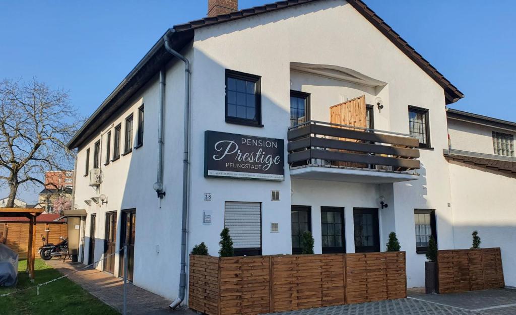 a white building with a sign on the side of it at Prestige Bistro & Pension in Pfungstadt
