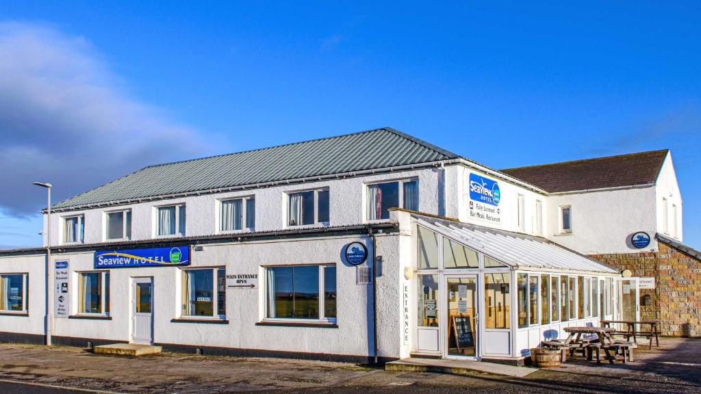 a large white building with a store front at Seaview John O Groats Hotel in John O Groats