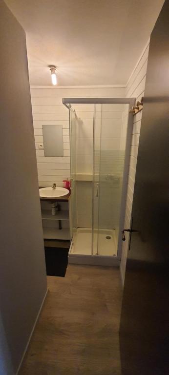 a bathroom with a glass shower and a sink at T2 tout confort pour 6 couchages in Hazebrouck