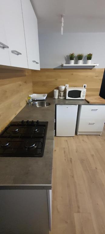 a kitchen with white cabinets and a stove top oven at T2 tout confort pour 6 couchages in Hazebrouck