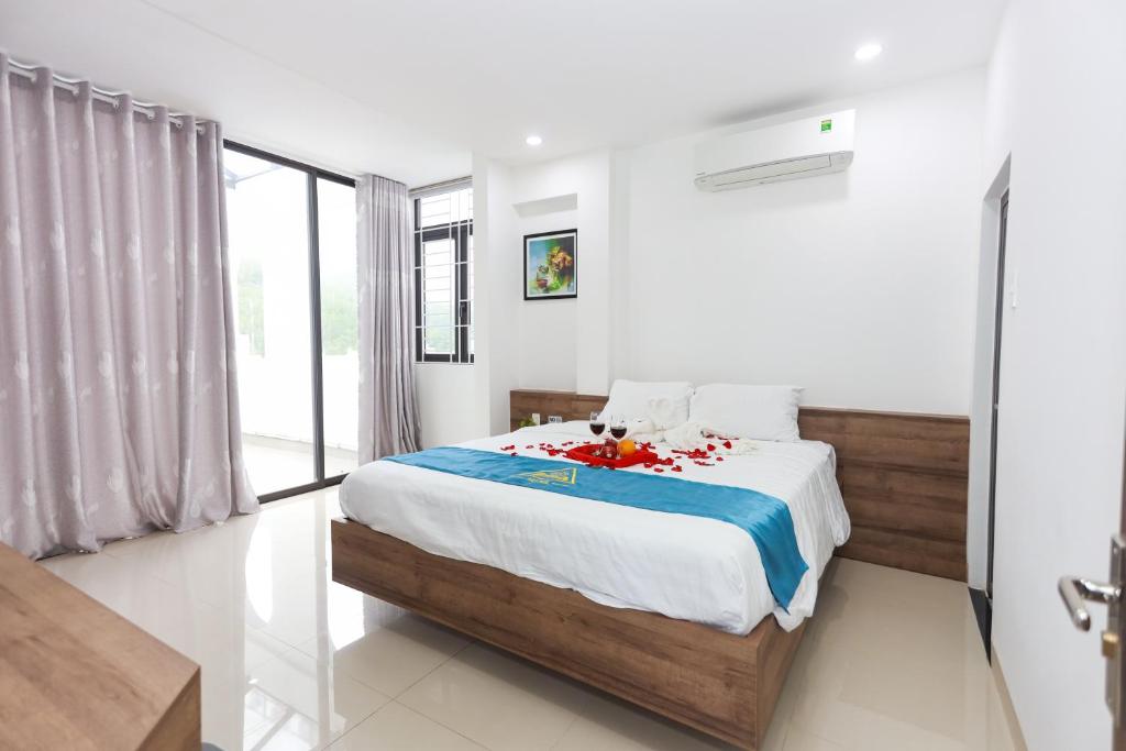 a bedroom with a bed and a large window at Học Hương Hotel Quy Nhơn in Quy Nhon