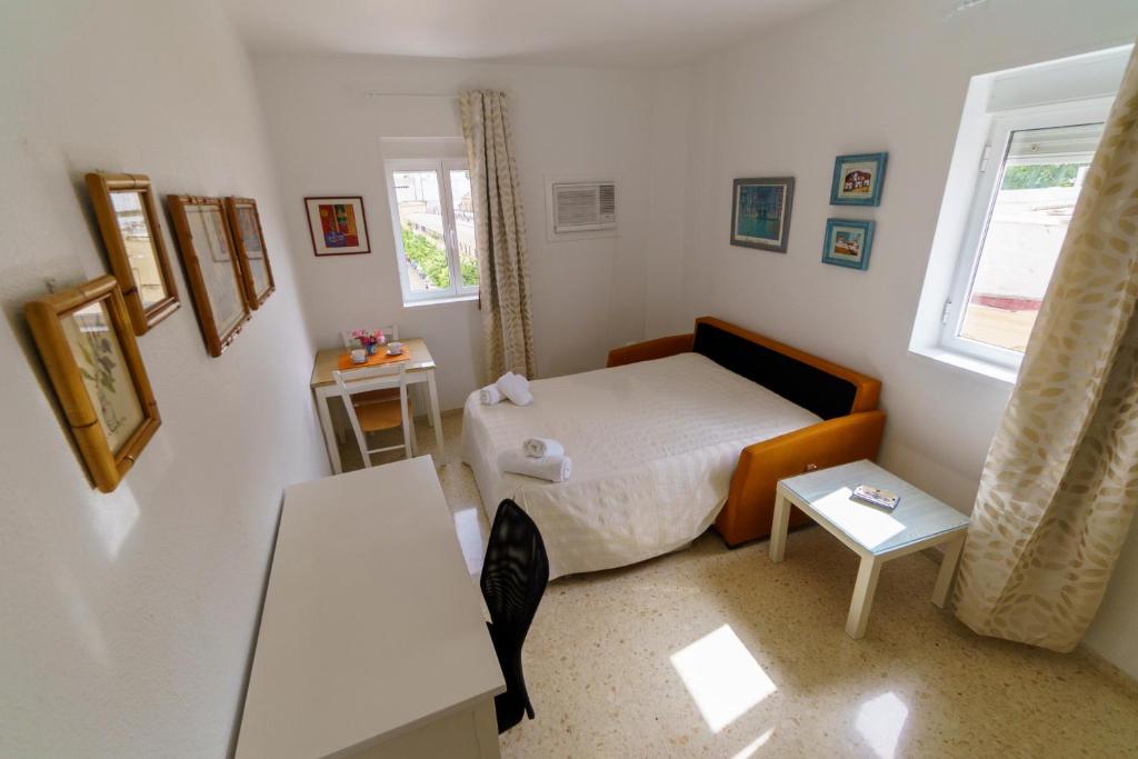 mała sypialnia z łóżkiem i stołem w obiekcie RentalSevilla Plaza del Zurraque w Sewilli