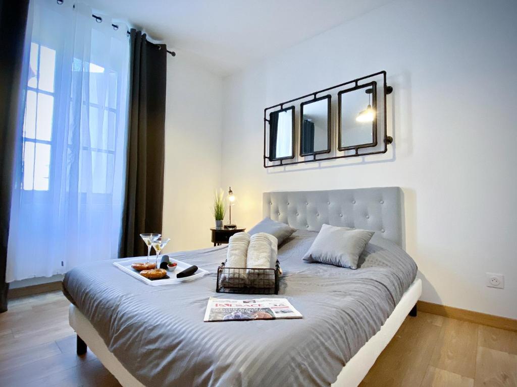a bedroom with a bed with a tray of food on it at Le convivial, appartement Centre ville Mulhouse in Mulhouse