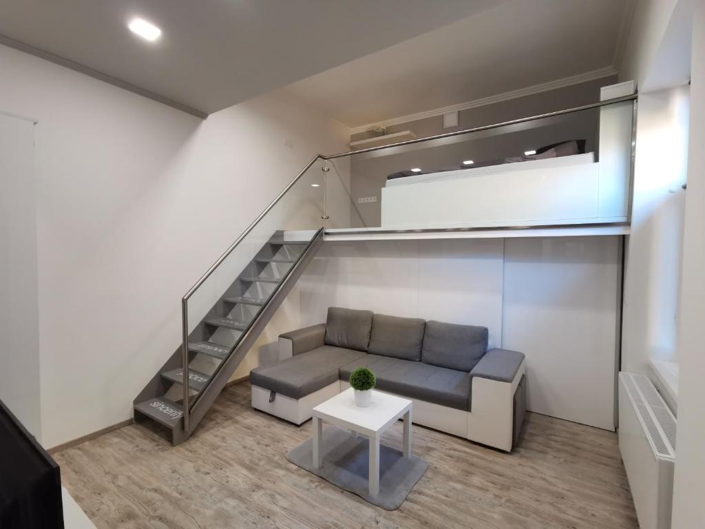 een woonkamer met een bank en een trap bij AApartman Exclusive in Pécs