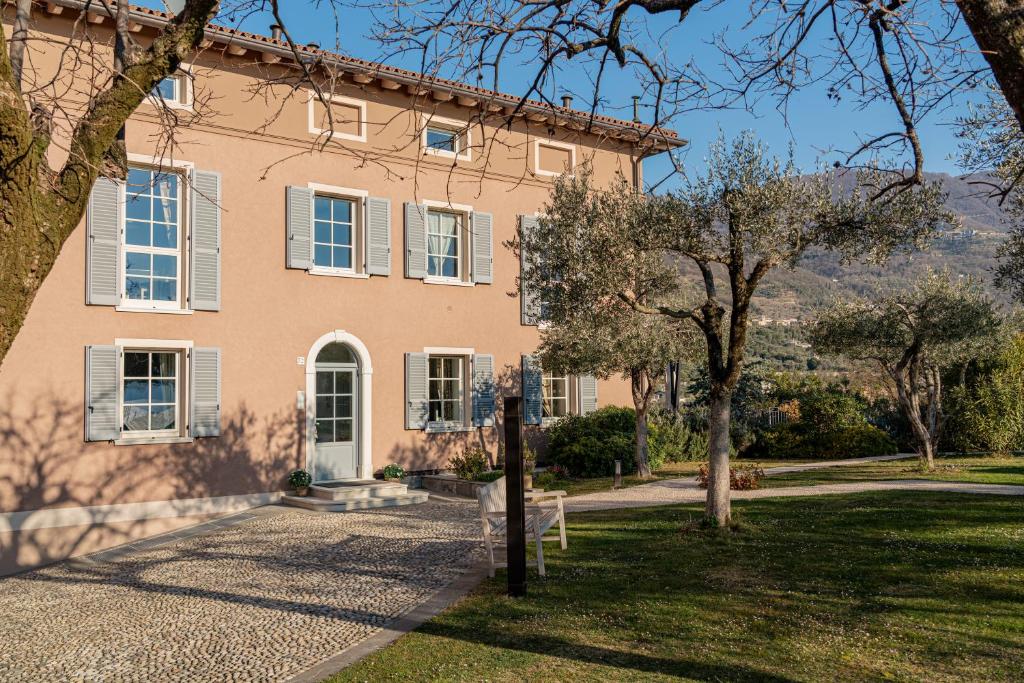 una gran casa rosa con árboles delante en San Giorgio Resort en Gargnano