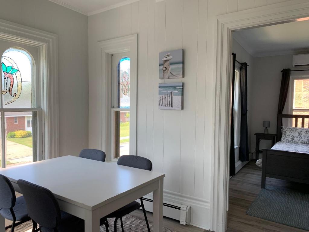 une salle à manger avec une table et des chaises blanches dans l'établissement County Cove - Consecon Suite, à Wellington