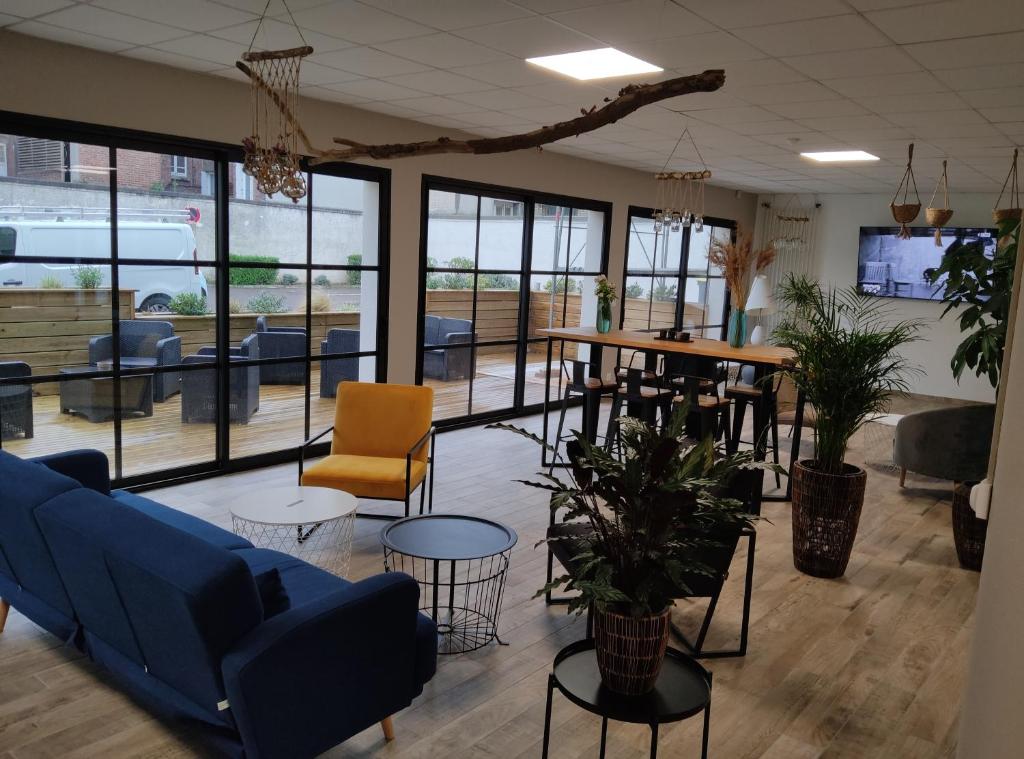 a lobby with a blue couch and chairs and tables at Villa Raphaëlle #4 Centre ville avec parking in Le Havre