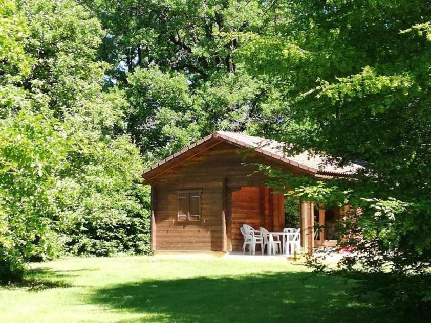 une cabane en rondins avec une table et des chaises dans la cour dans l'établissement Le Clos des Chênes, à Saint-Geniès
