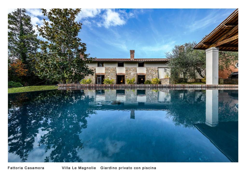 a swimming pool in front of a house at Fattoria Casamora - Villa Le Magnolie in Pian di Scò