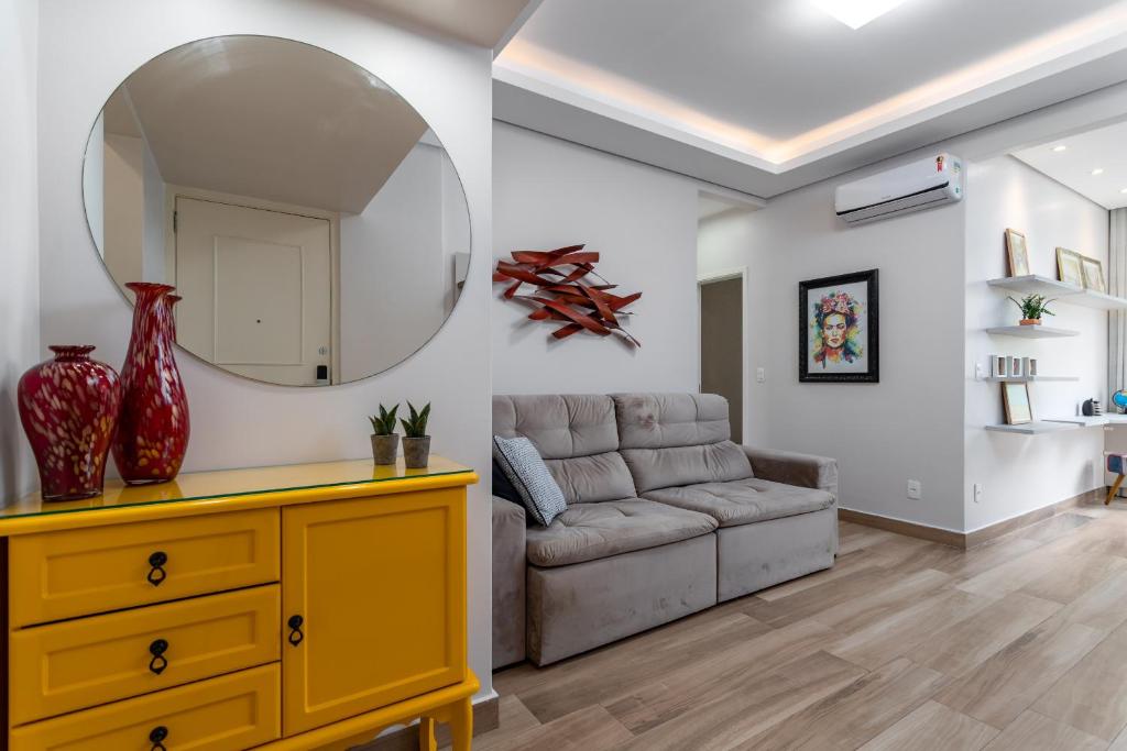 ein Wohnzimmer mit einem Sofa und einem Spiegel in der Unterkunft Moderno em Copacabana - Ideal para casais - SC305LT Z4 in Rio de Janeiro