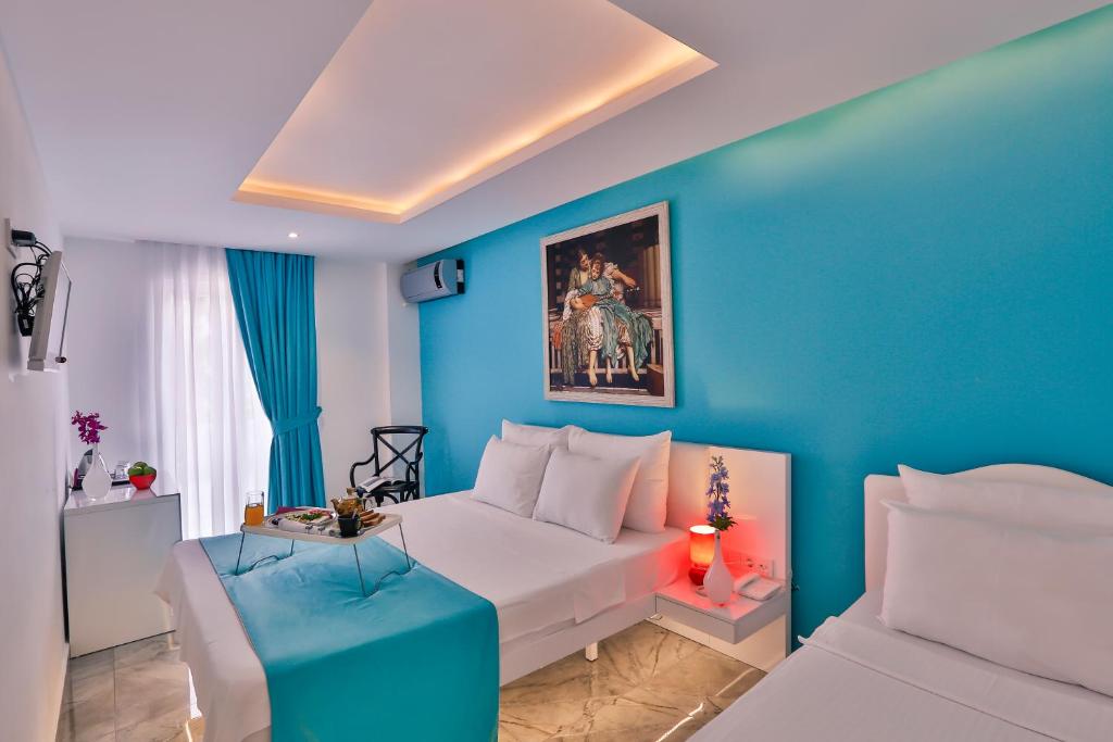 فندق بيليزا أورتاكوي في إسطنبول: غرفة نوم زرقاء مع سرير أبيض وجدار أزرق