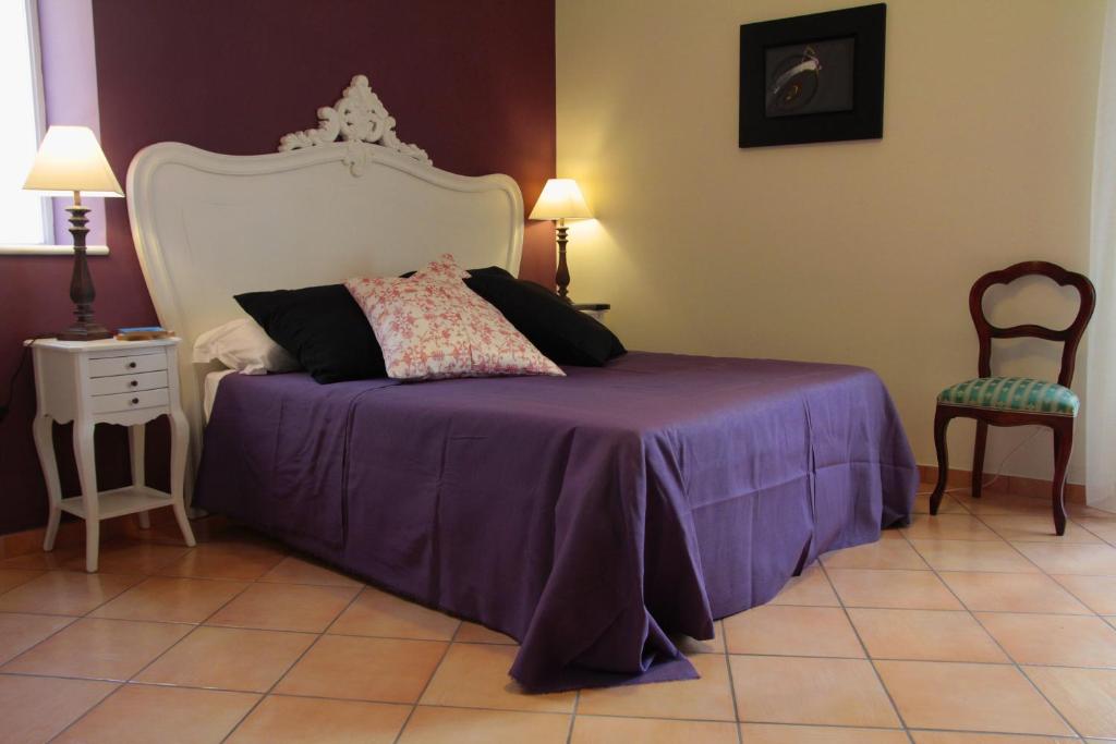 Un dormitorio con una cama con sábanas moradas y una silla en B&B Verdi, en Salerno