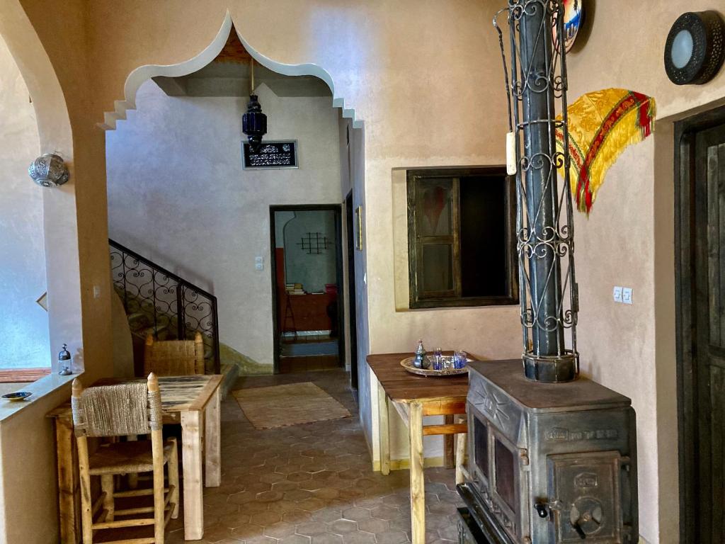 a living room with a wood stove and a table at Les 4 Saisons Du Dades in Aït Idaïr