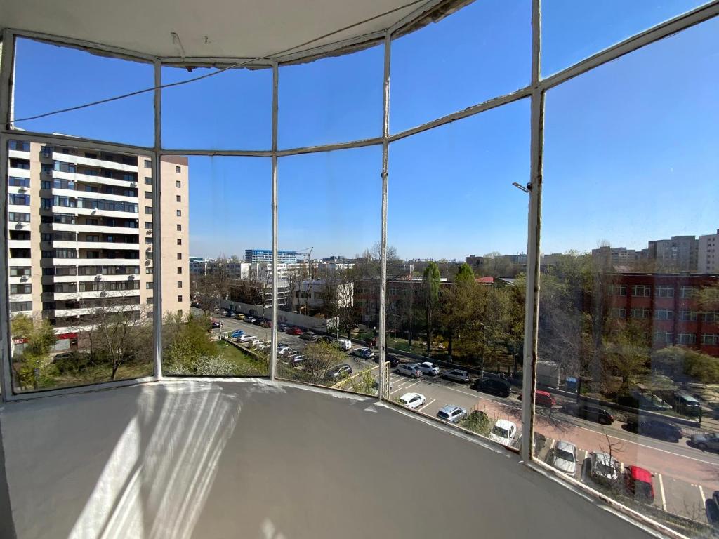 een groot raam met uitzicht op een stad bij Le Garçon de Adi-Cosy,Quiet,Spatious Studio in Boekarest