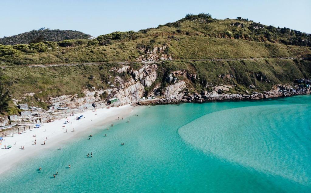 una vista aérea de una playa con gente en el agua en Arraial do Cabo - Brisas do Farol - Aluguel Econômico, en Arraial do Cabo