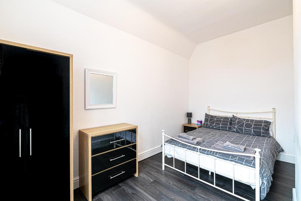 a bedroom with a bed and a dresser in it at Two bedroom holiday apartment Colwyn Bay in Colwyn Bay
