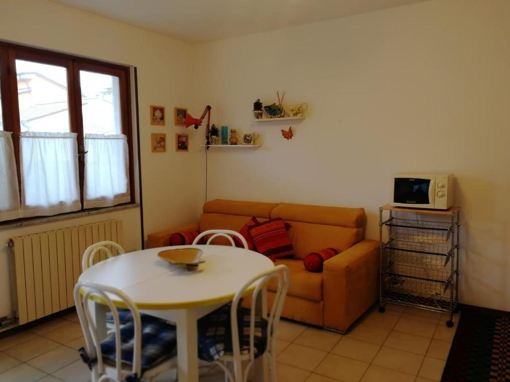 sala de estar con mesa y sofá en la casa dei bebi, en Carrara