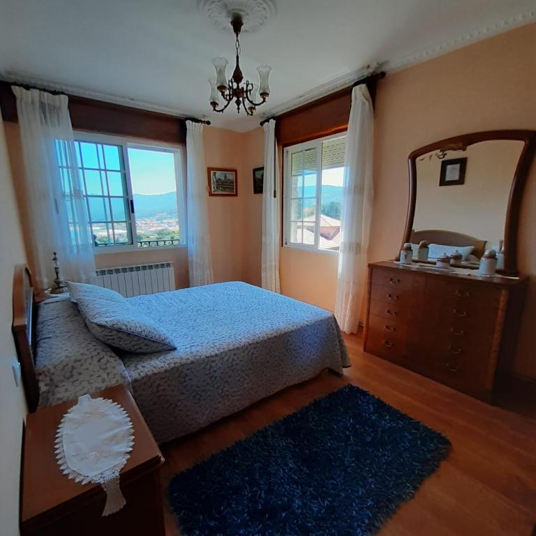 1 dormitorio con cama, tocador y espejo en CRUCEIRO DE HIO, en Hío
