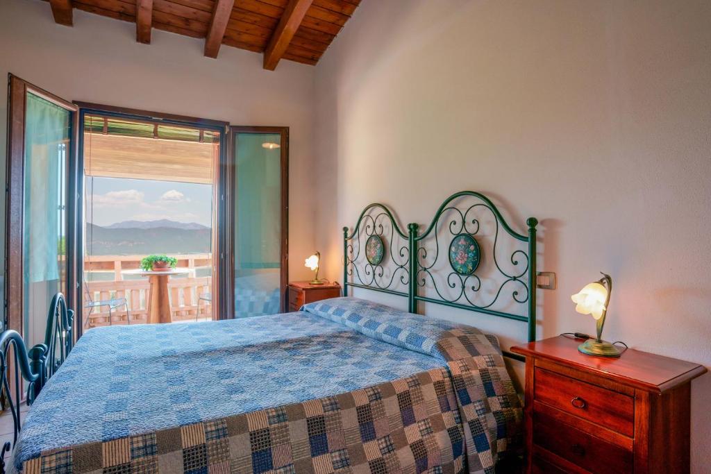 a bedroom with a bed and a view of a balcony at L'Oasi del Cervo in Arbus