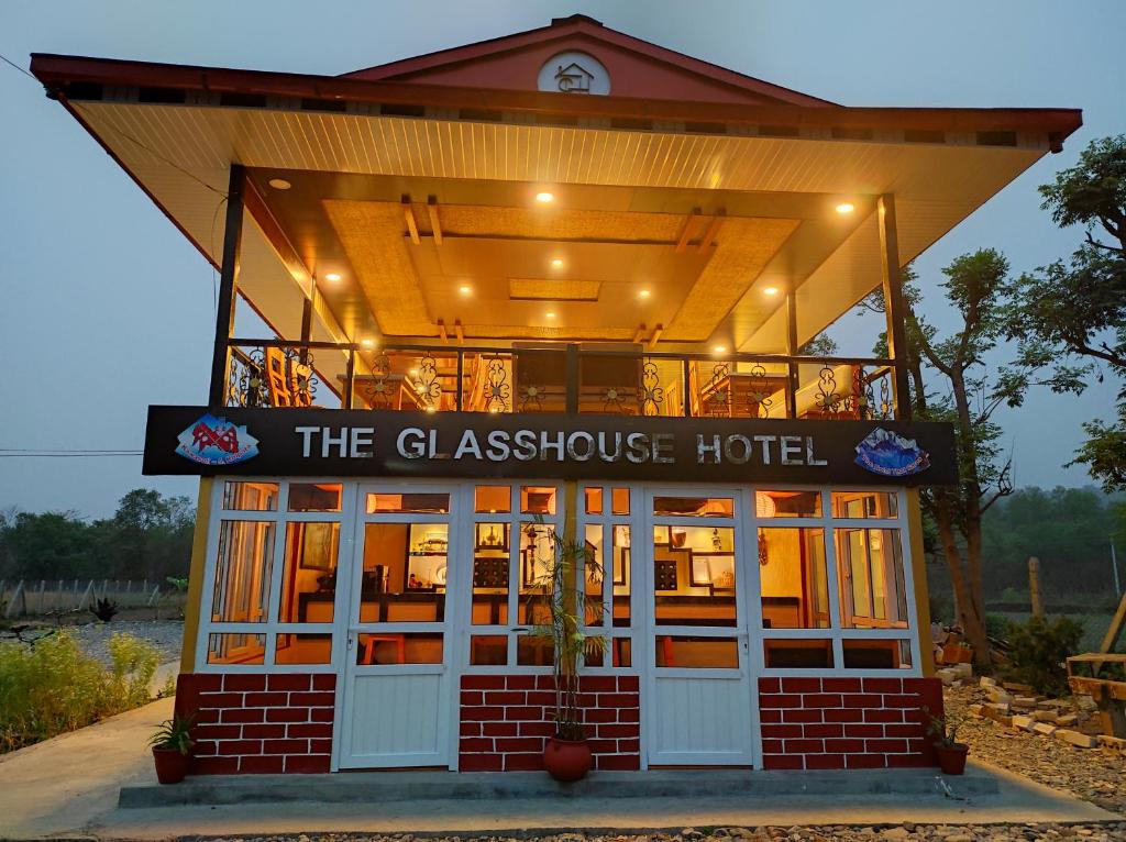 un restaurant avec un panneau indiquant l'hôtel en verre dans l'établissement The Glasshouse Hotel, à Kawasoti