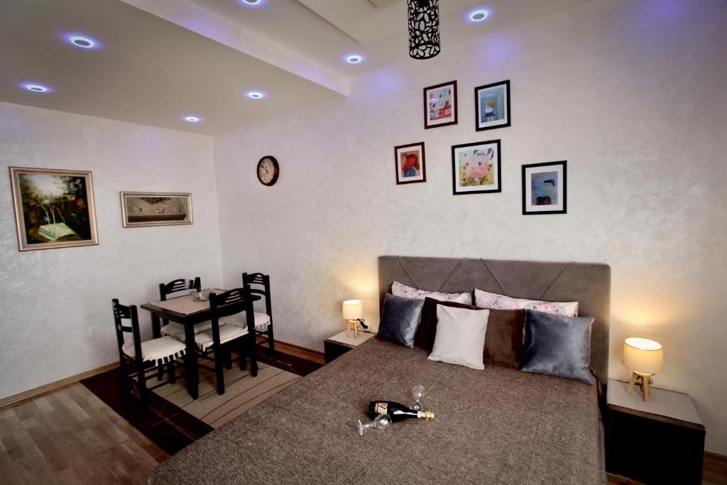 ein Schlafzimmer mit einem Bett und einem Tisch mit einem Tisch in der Unterkunft Apartment Bohemian Dream in Nikšić