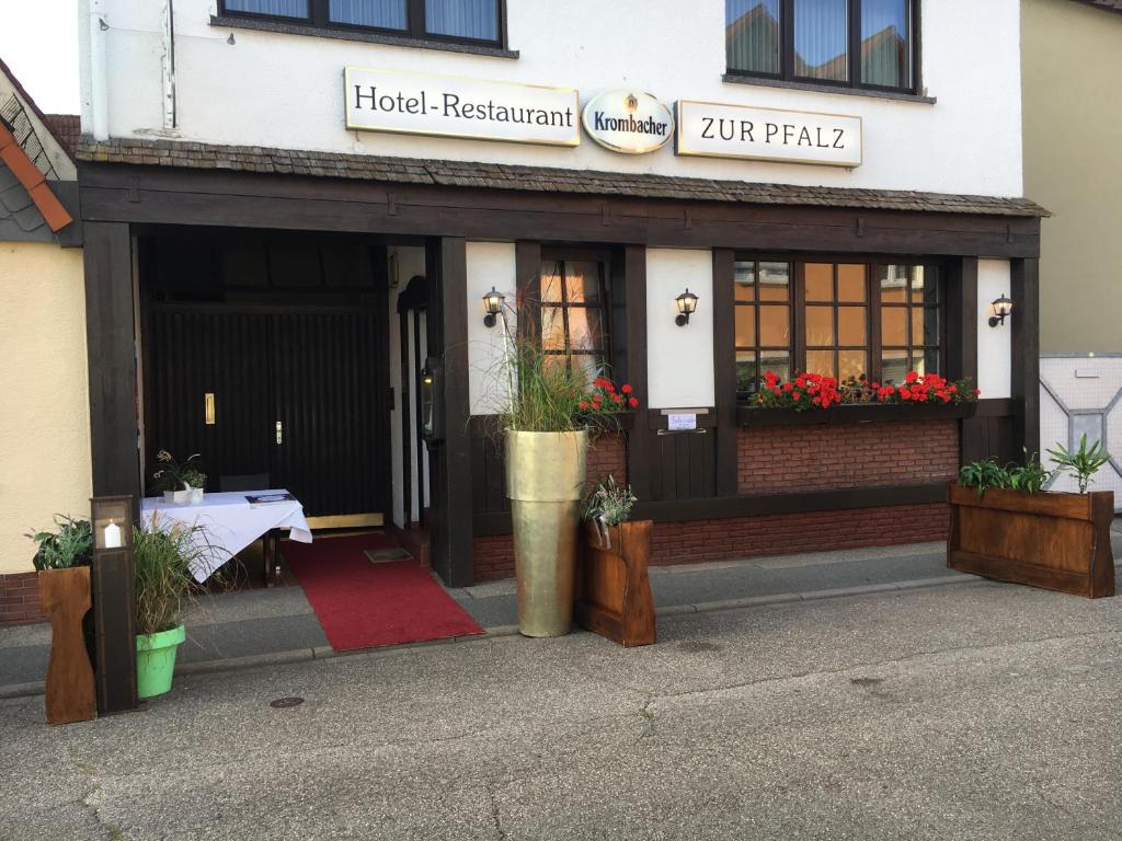 a hotel restaurant with a table in front of a building at Hotel und Restaurant -Gasthaus Zur Pfalz in Hockenheim