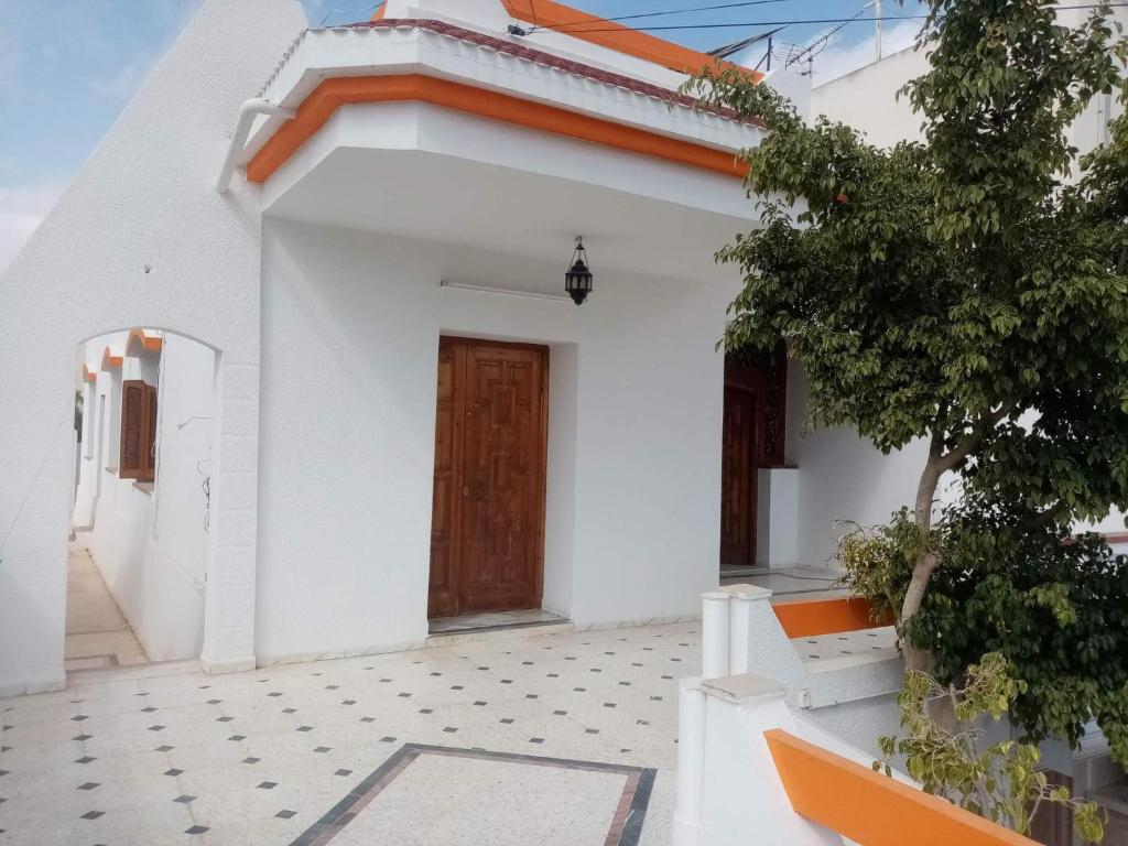 ein weißes Haus mit einer Tür und einem Innenhof in der Unterkunft Villa luxueuse meublée in Sfax