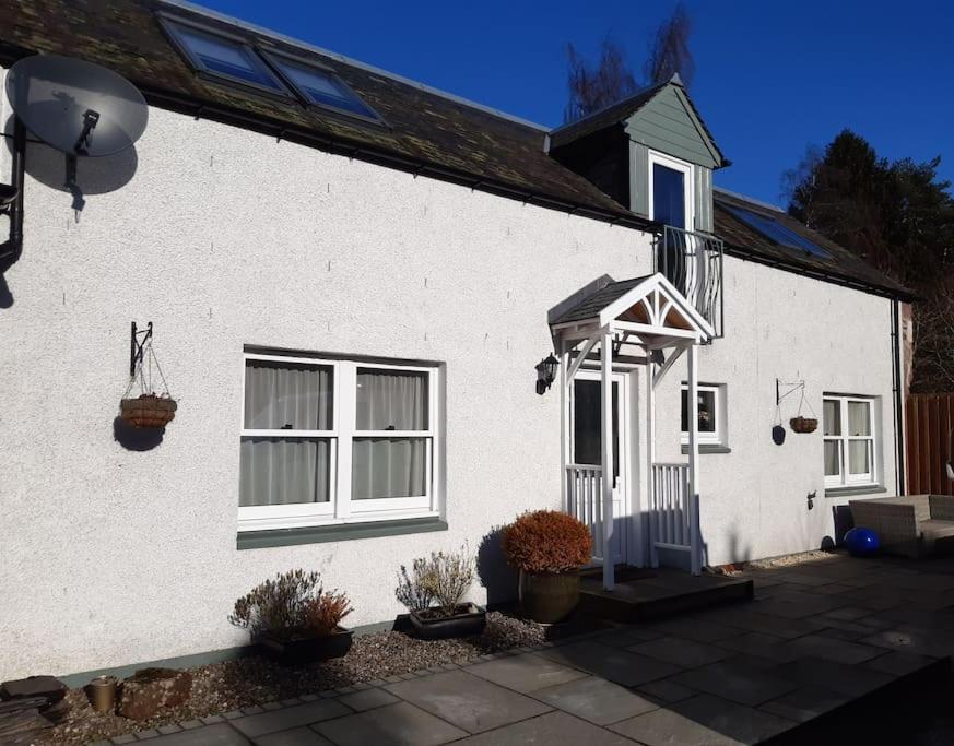 a white house with a white door and windows at Pinewood Cotage - Country Walks and Relaxation in Blairgowrie