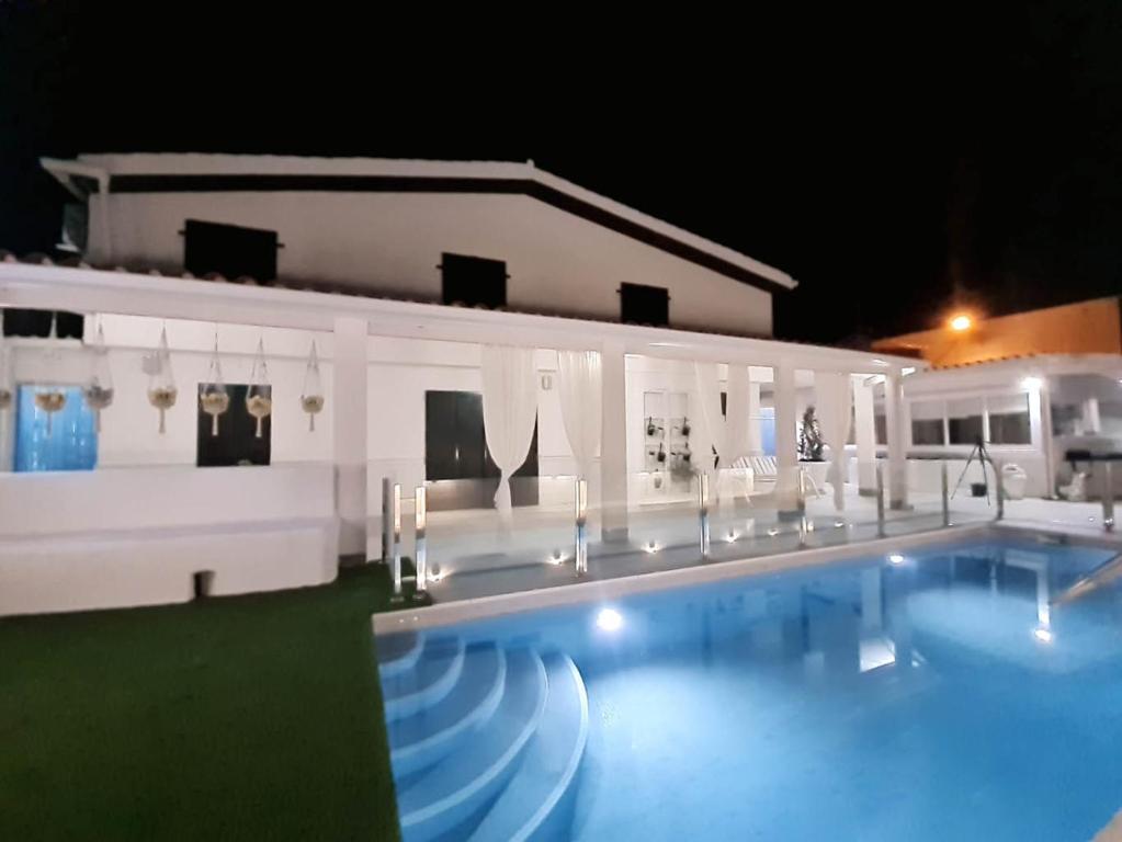 una piscina frente a una casa por la noche en Casa rural Aldea, en La Alameda de Cervera
