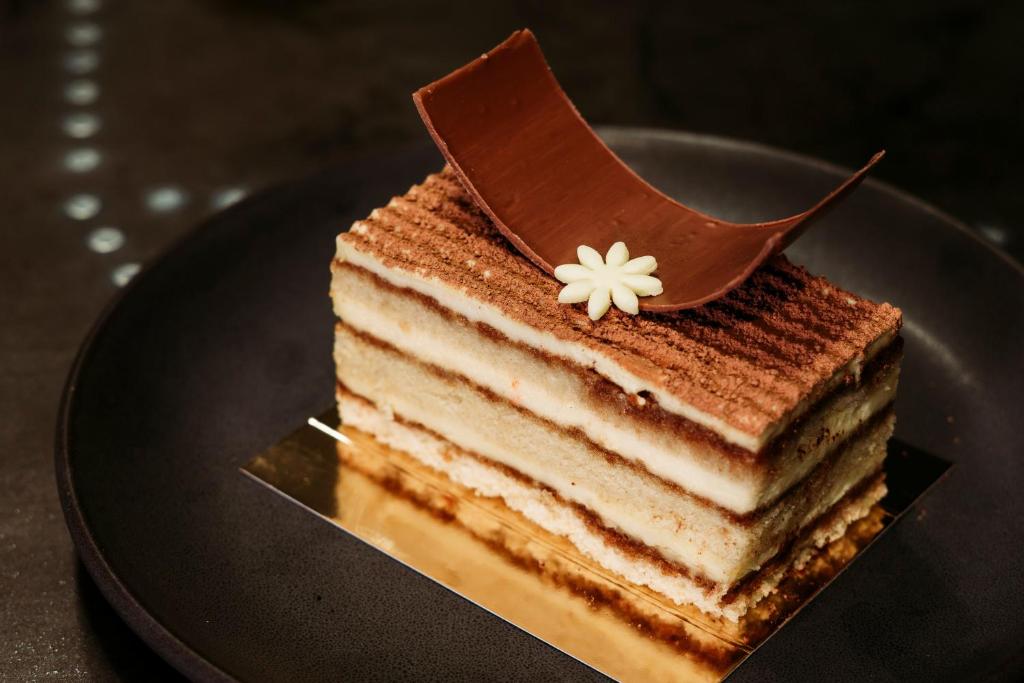 a three layer cake on a plate on a table at InterContinental Muscat by IHG in Muscat