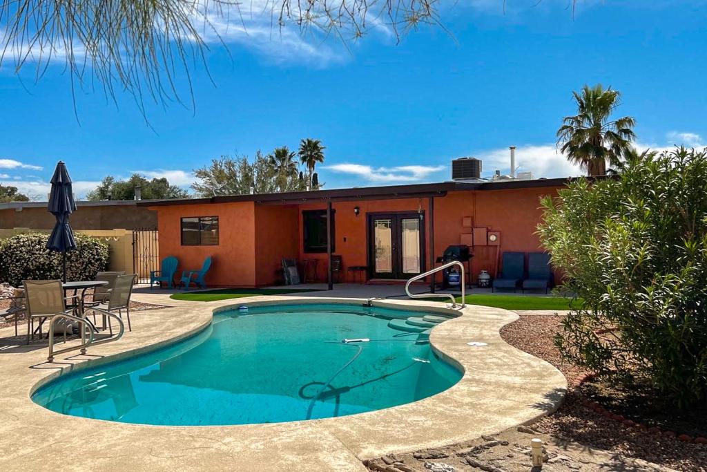 a swimming pool with a house in the background at Jupiter Coyote in Tucson