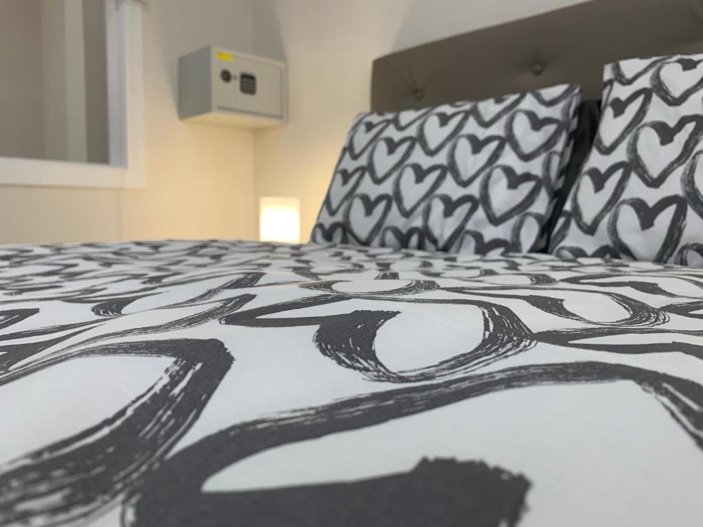 a bed with a black and white blanket and pillows at Casa Pablo II Aptº Tranquilo, a cinco minutos del Puerto de la Cruz in Los Realejos