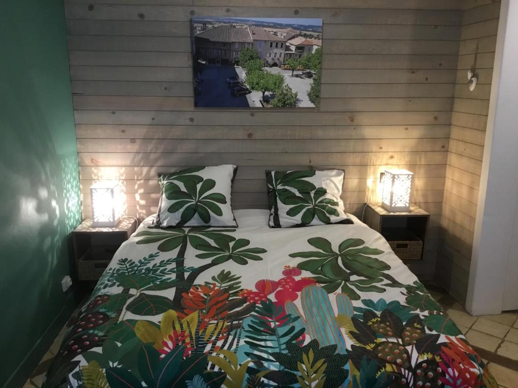 モンフランカンにあるLa Cambra dé Monflanquinのベッドルーム1室(カラフルな掛け布団付きのベッド1台付)