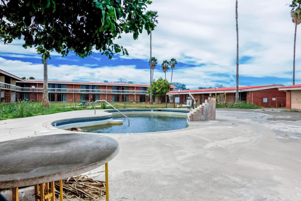 une piscine dans la cour d'une école avec un bâtiment dans l'établissement OYO Hotel Alice TX Hwy 281 West, à Alice