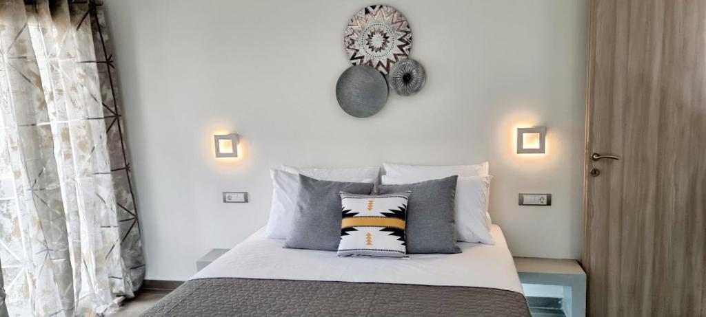 a bedroom with a bed with pillows and a clock on the wall at Ether in Perivolos