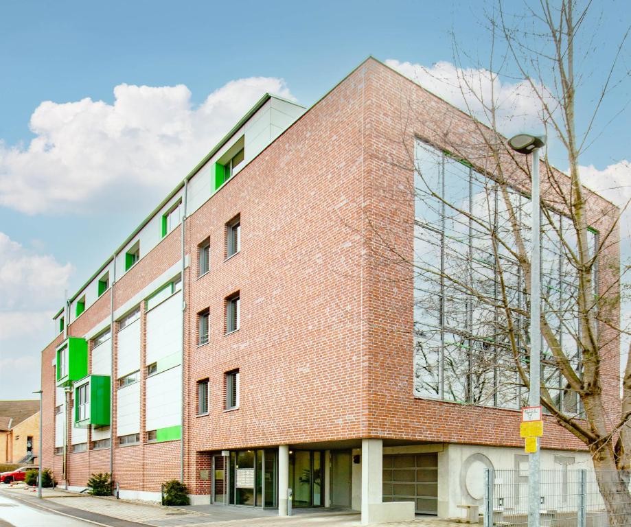 un edificio de ladrillo rojo con ventanas verdes en Gohlke L.O.F.T. Apartments, en Schorndorf