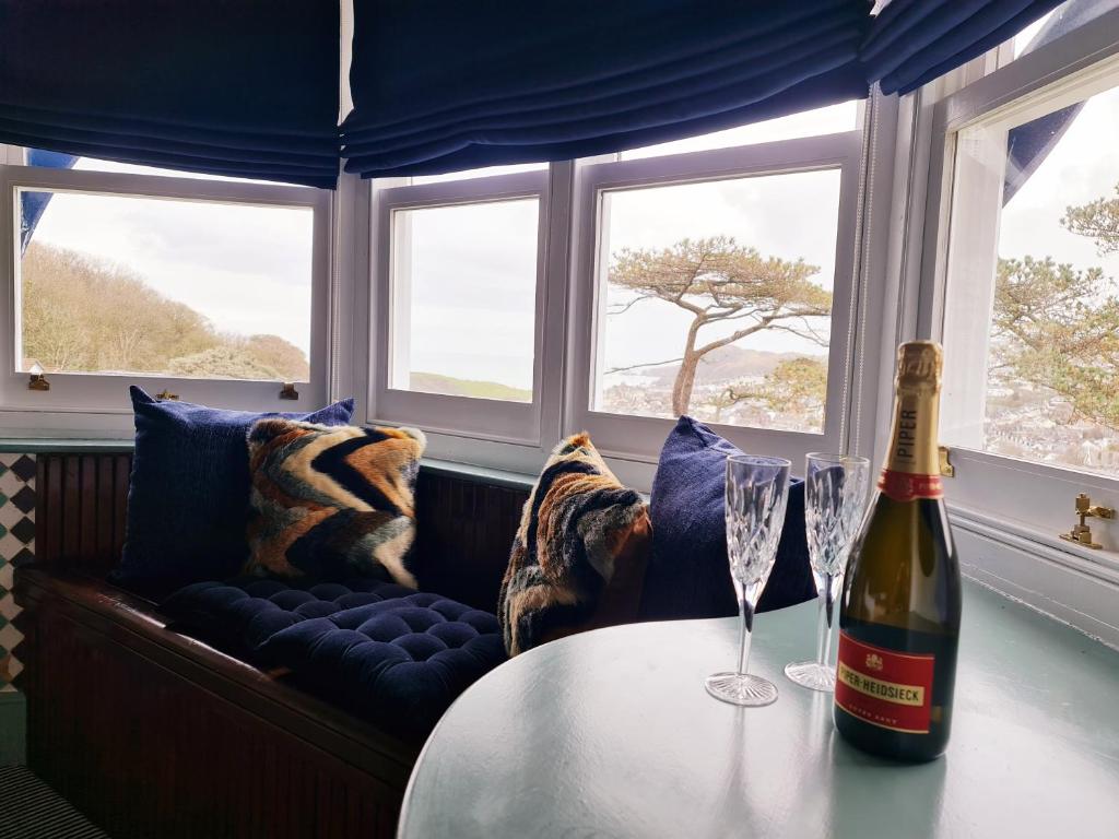 a bottle of wine sitting on a table with two wine glasses at Westwell Hall Guest Accommodation, Bed & Breakfast, Luxury Rooms - Room Only Accommodation OR Self Catered Apartment in Ilfracombe