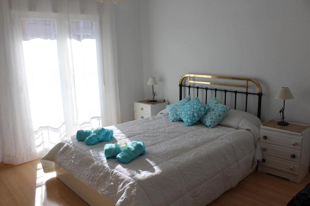 a bedroom with a large bed with blue towels on it at El Refugio in Calatayud